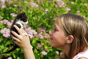 Choosing: Cat - young black & white kitten being held by girl
