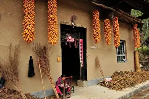 Qinling: Child - doing homework outside farmer's house -