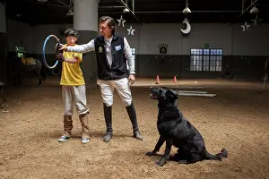 Held: Child listening to the instructions of trust with a dog