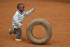 Tribal: Child playing with tire, near Eldoret, Kenya, Kalenjin