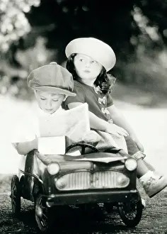 Reading: Children - boy and girl in toy car reading map