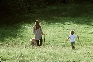 Hobbies: CHILDREN - boy and girl walking dog in meadow