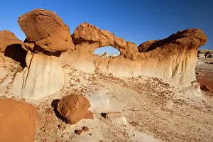 Amidst: Chocolate Arch - brown rock arch sitting in a clay