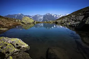 Quiet: A clear mountain lake reflects the surrounding peaks in calm