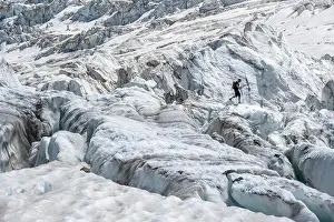 Crack: Climber walking on rutted glacier, glacier ice with