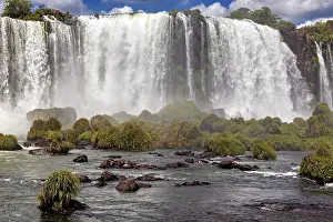 Waterfalls: Close-up of a powerful waterfall with lush vegetation and spray