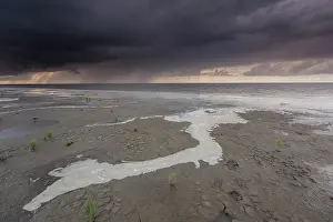 Raining: Clouds above the Waddensea at low tide during sunset