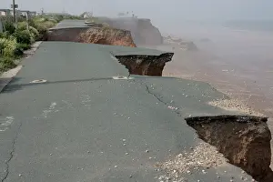Collapsed: Collapsed tarmac road following cliff erosion on