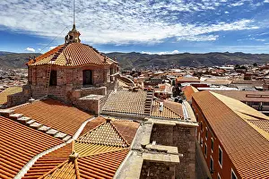Typical: Colonial building with traditional roof tiles and mountain backdrop under a blue sky