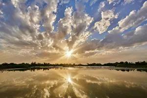 Camargue: Colored Clouds above a lake with greater Flamingo