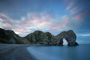 Features: Colorful sky at dawn over Durdle Door along the