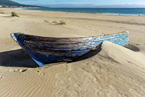 Gibraltar: A colorful wreck of an old wooden rowboat buried in the sand