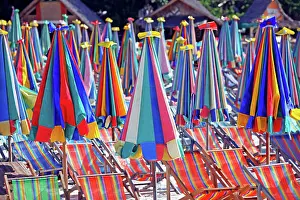 300517: Colourful beach umbrellas and deckchairs for a summer ho