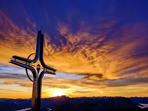 Chiemgau: Colourful clouds at dawn, summit cross Hoher Gnll