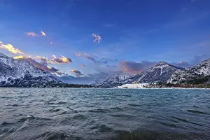 Waves: Colourful clouds in the sky at dawn on a winter morning over Waterton Lake