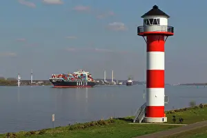 Ships: Container ships on the Elbe River pass lighthouse