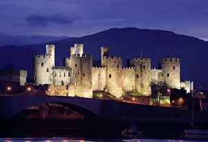 Conwy: Conwy Castle - being lit up at dusk - November