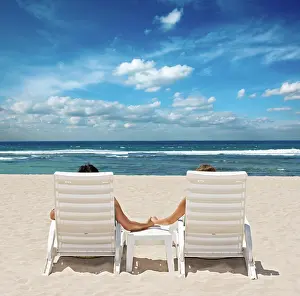 Silence: Couple in beach chairs holding hands near ocean