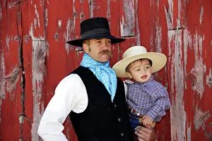 Cattleman: Cowboy carrying child