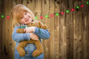 Decorated: Cute little girl holding her teddy bear in front