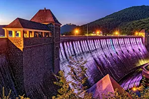 Economy: Dam in the evening light, bright purple illuminated
