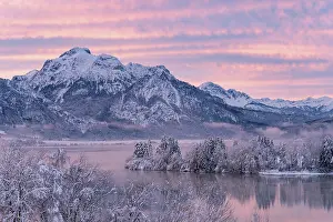 Alpine Upland: Dawn and sunrise at the wintry Forggensee in a snow-covered
