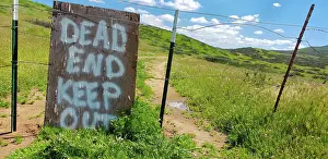 Sign: Dead end keep out sign on wire fence at dirt road