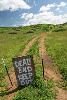 Sign: Dead end keep out sign on wire fence at dirt road