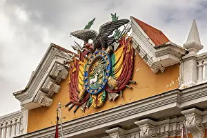 Cities: Detailed coat of arms with eagle on a historic building under a cloudy sky