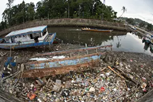 Garbage: Dilapidated boats - on land with garbage by river
