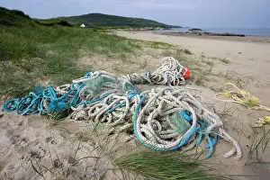 Ropes: Discarded rope and fishing net washed up on sandy beach
