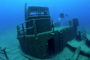 Scooter: Diver exploring with scooter the LST 349, a British Landing
