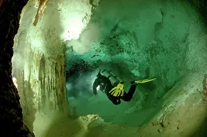 Yucatan: Diver with torch - Cave dving Maya Cenotes Yucatan Mexico