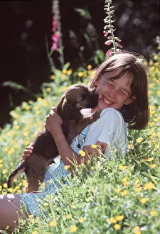 Stroking: DOG - PUPPY - LICKING GIRL'S FACE in flowers