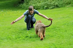 Squatting: Dog - Puppy running towards woman squatting with arms open