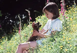 Stroking: DOG - puppy stroked by girl, flowers