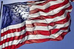 Waving: Dramatic backlit american flag waving in the wind