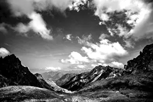 Austrias: Dramatic black and white image of a rocky mountain landscape under a cloudy sky
