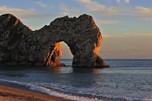 Devon: Durdle Door, a natural limestone arch at sunset