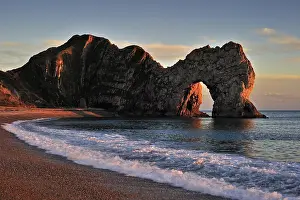 Devon: Durdle Door, a natural limestone arch at sunset