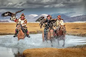Hunter: Eagle hunters crossing the small river. Western Mongolia