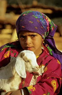 Nomads: Egypt - a Bedouin girl cuddles a goat; a small