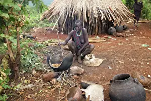 Beer: Ethiopia - woman fermenting beer outside hut