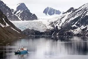Surrounded: Expedition ship lies at anchor in a fjord surrounded by snow