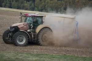Tractors: Farm Tractor - veiled in dust, sowing out seed