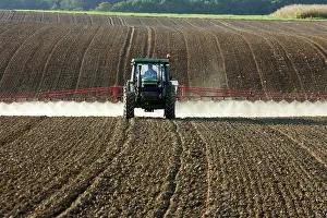 Chemicals: Farming - farmer spraying crops in tractor