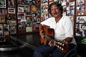 Instruments: Female Cuban musician playing the guitar in a Casa