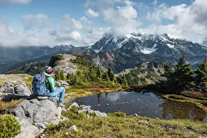Baker: Female hiker resting on a rock at a small mountain