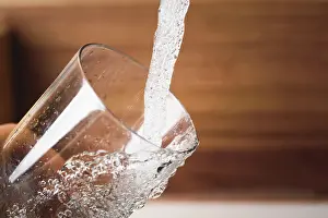 Style: Filling glass of water from stainless steel kitchen