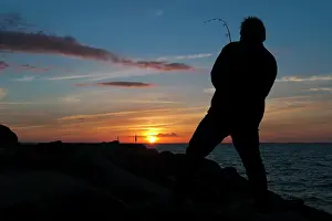 Anglers: Fisher at sunset on the pier, Lohme, Ruegen island